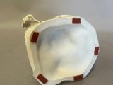 a white vase with a red stripe on it