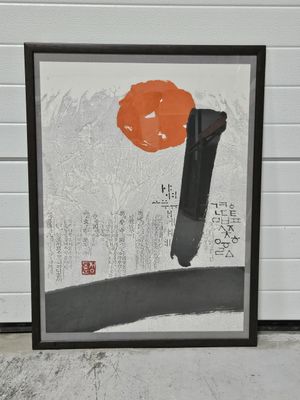 tableau représentant une fleur d'oranger dans un cadre noir, sur fond de mur de briques blanches