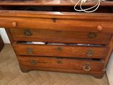 a dresser with a mirror and a lamp on top of it