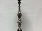 an antique silver plated candle holder on a wooden table