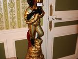 une statue représentant un homme tenant un verre de vin dans une pièce