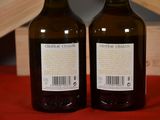 two bottles of wine sitting on top of a table next to a wooden crate