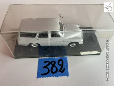 une petite voiture miniature dans une boîte transparente avec une étiquette de prix