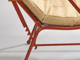 an image of a red chair with a beige cushion and a wooden table
