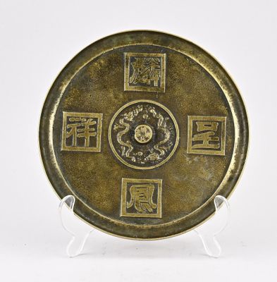une plaque en laiton ancien ornée d'inscriptions et de symboles chinois