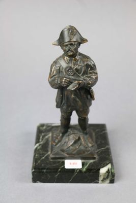 bronze figurine of a man in a pirate hat holding a gun