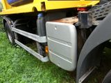 a yellow dump truck that is parked in the grass