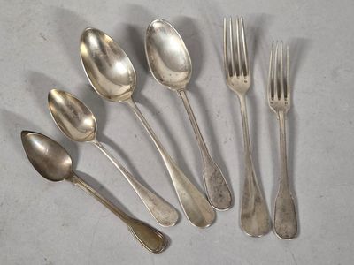 six silver spoons and a fork on a white surface