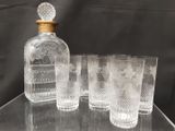 quatre verres et une carafe posés sur une table