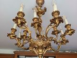 un lustre doré dans un salon, avec des bibliothèques en arrière-plan