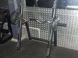 une photo d'une salle de sport avec une barre et des haltères