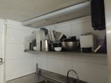 many pots and pans on the shelf in the kitchen