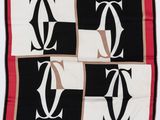 une écharpe noire, blanche et rouge sur laquelle figure la lettre « c »