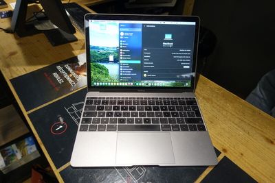un ordinateur portable posé sur une table en bois