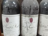three bottles of wine are sitting on a shelf in a wine cellar