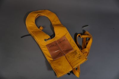 un tablier jaune et une paire de ciseaux posés sur une table