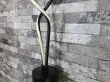 a black and white sculpture on a shelf in front of a brick wall