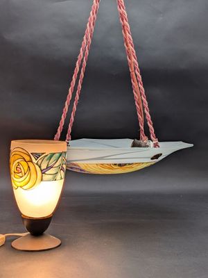 une planche de surf suspendue à une corde, sur laquelle est fixée une lampe
