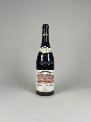 the bottle of wine is sitting on a white surface