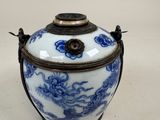 un vase bleu et blanc posé sur une surface blanche