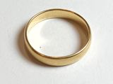 gros plan d'une bague en or sur une surface blanche
