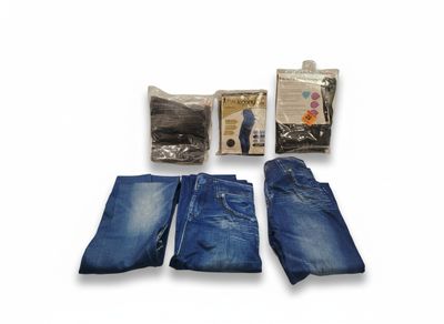 trois paires de jeans et un paquet de mouchoirs posés sur une surface blanche