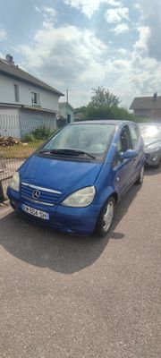 une petite voiture bleue garée sur le bord de la route