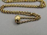 a close up of a gold chain with a bell on it