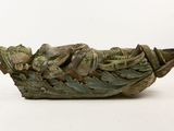 a sculpture of a man in a boat on a white surface