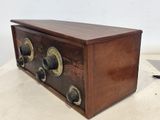 an old fashioned radio sitting on top of a table next to a white wall