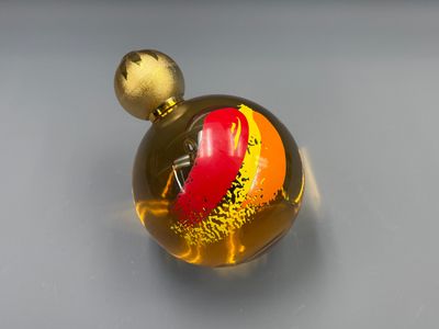 a glass ball with a red and yellow design on it