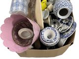 une boîte en carton remplie d'objets divers posée sur une surface blanche