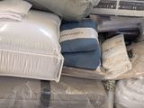 a pile of pillows, blankets, and blankets on a bed