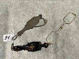 deux paires de lunettes et une paire de ciseaux posées sur une table