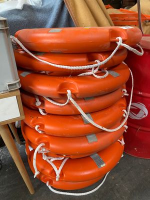 de nombreux gilets de sauvetage orange empilés les uns sur les autres