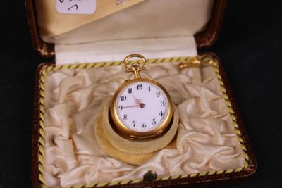 a small gold pocket watch in a case