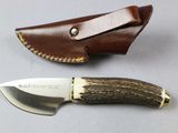 a knife that is sitting next to a leather sheath