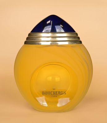 un bocal jaune avec un couvercle bleu posé sur une surface beige