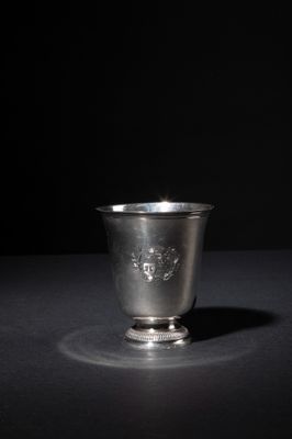 an old silver cup sitting on top of a black table