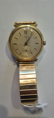 une montre en or sur une surface blanche avec un fond blanc