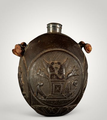 une vieille gourde en métal ornée d'un motif