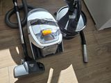 a vacuum that is sitting on the floor next to a bowl
