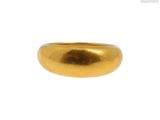 une image d'un gros plan d'une bague en or sur un fond blanc