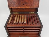 an open box of cigars sitting on top of a white surface