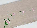 a close up of a table runner with pink flowers on it