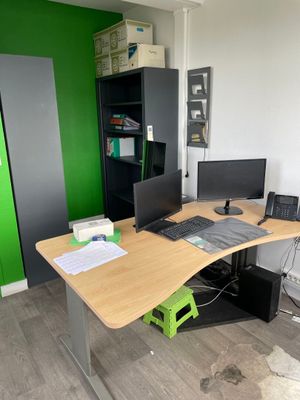 un bureau sur lequel sont posés deux écrans et un ordinateur portable