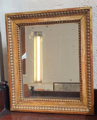 un miroir posé sur une table, avec une lampe à l'intérieur