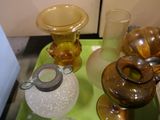 a green tray with glass vases and other items on it