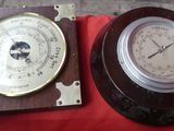 two clocks sitting on a red cloth on a table