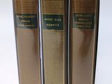 three books sitting on top of each other on a white surface